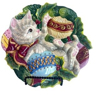 Cute Gray Kitten Plays with Christmas Tree Ornaments on a Decorative Plate.
